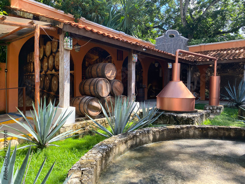 Production of tequila in Mexico. Old factory for the production of tequila. Side view of the barrels of alcohol in the yard of the factory. Concept of tourism and traditions.
