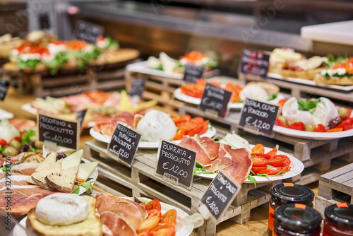 Various snacks and antipasti on the table of showcase. Street food market in Florence, Italy. photo