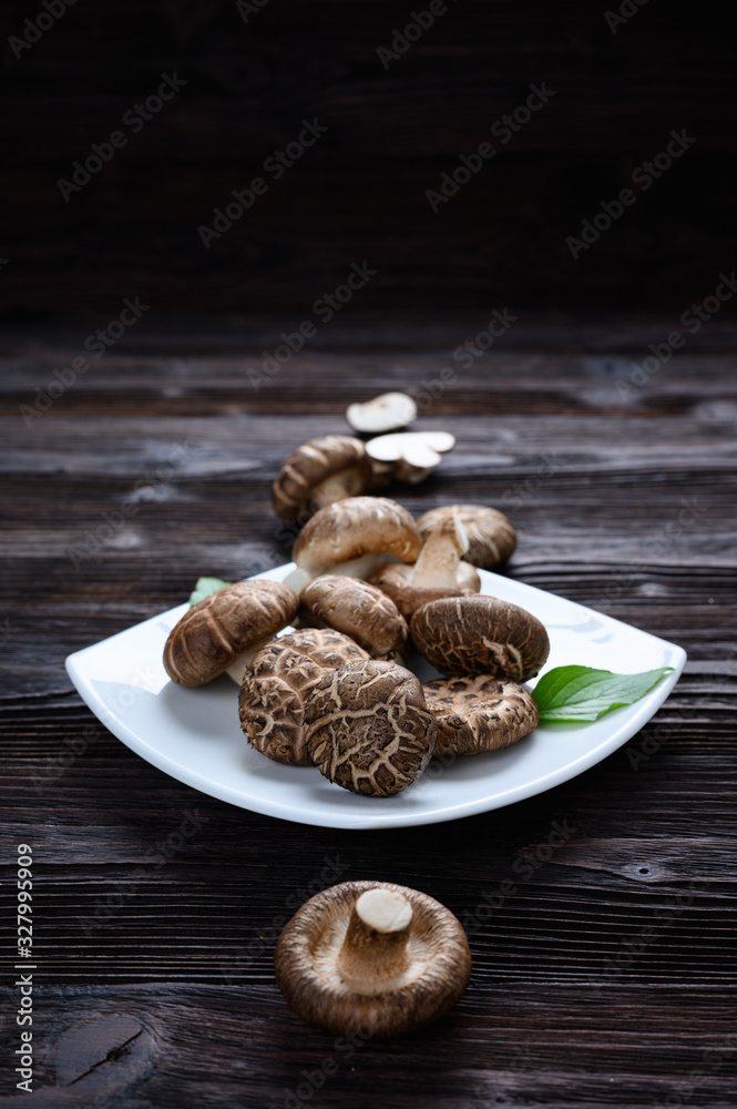 Fototapeta premium Shiitake mushrooms on the wooden background.