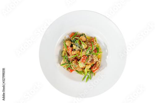 Potatoes with meat, chicken, pork, zucchini, tomato, sesame seeds and green onions, with teriyaki sauce, fried, baked portion on plate, on a wooden board on white background view from above