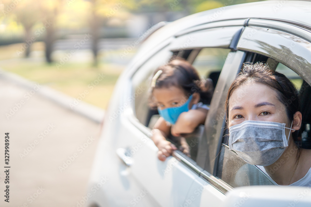 Mum and daughter wearing Medical Disposable Face Mask to prevent pollution, flu and convid-19 in car.