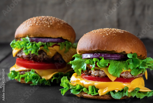Two fresh hamburger on dark stone table. closeup. Shallow depth of field.