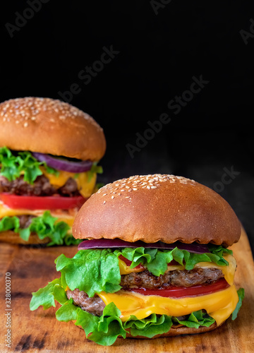 Two fresh hamburger on a wooden table. Closeup. Shallow depth of field.