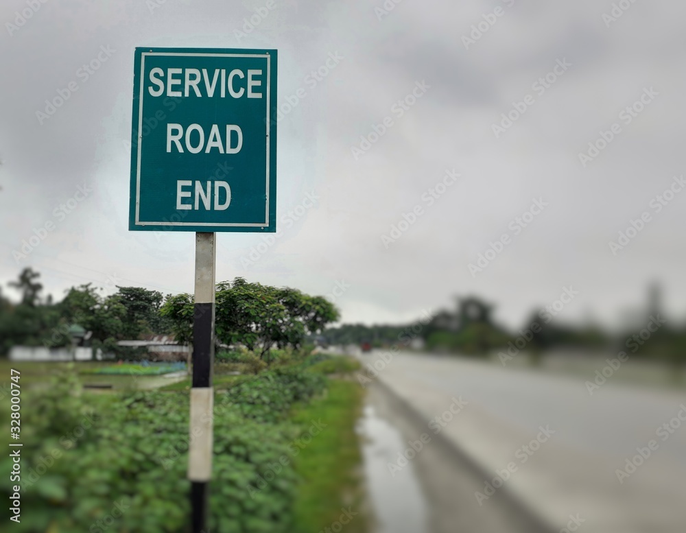 Service road end white text on green board at the highway