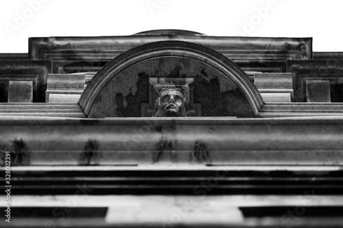 detail of face on roofline of old building