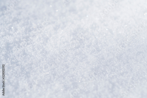 Background of fresh white snow. Winter snowflakes texture. Snow white texture winter background. Icy surface pattern. Shiny snow with bokeh