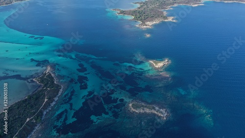 Aerial footage of small islets in turquoise water of Aegean sea, Halkidiki, Sithonia peninsula, Vourvourou beach, Kavourotripes beach, Greece. Beautiful landscape. Small islands. Stones underwater.