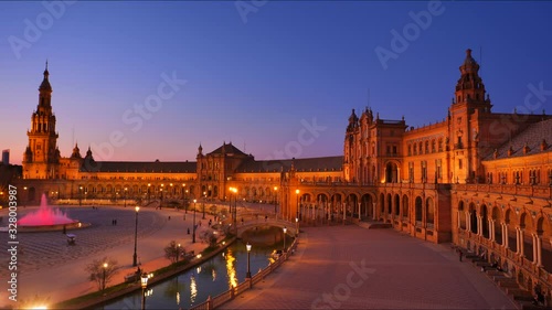 4K Timelapse at Blue Hour of tourists strolling and admiring the famous plaza de Espana in Seville City Center with Architecture Details and beautiful centered fountain.