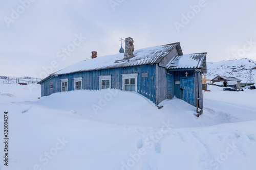 Abandoned hut-chapel swept by snow in the old fishing village of Teriberka, Kola Peninsula, Russia