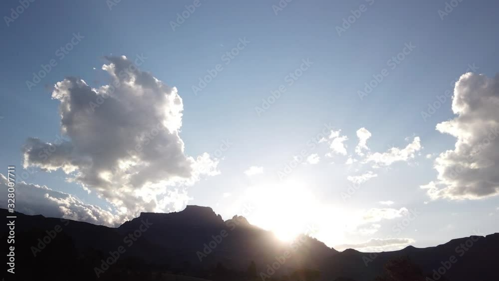 Stunning hyper time-lapse of the sunset behind Dragons Peak, Drakensberg Mountains, South Africa, lens flare, rolling clouds, sunbeams