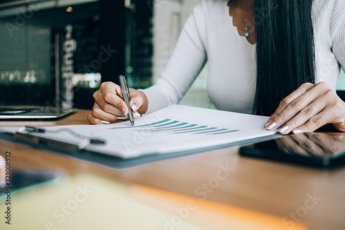 Businesswomen analyzing investment graph and discussing plan in meeting room, investment concept