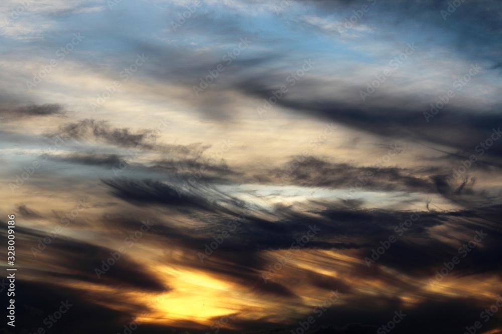 evocative sunset image with black clouds and blue sky