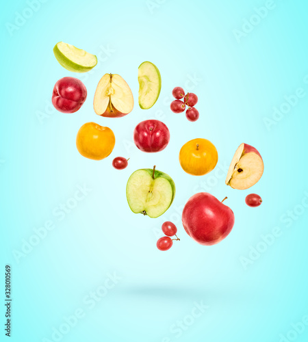 Flying Fruits healthy food summer color background. Apple  plum  grape. Colorful levitation  falling fly fruit creative vitamin concept. Fresh tropical fruit on blue