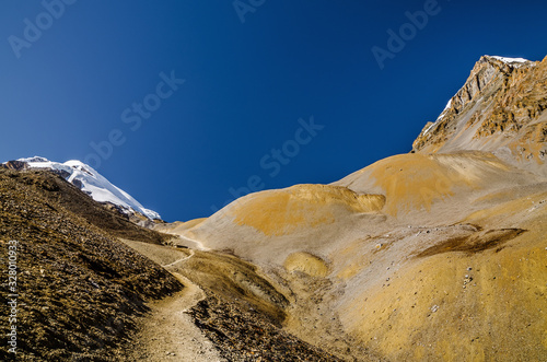 Trekking route to Thorung La pass between Yakwakang and Thorung peak on the horizon. Annapurna circuit trek, Nepal. photo