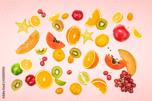 Flying Fruits healthy food summer color background. Papaya  orange  apple  kiwi  melon. Colorful levitation  falling fly fruit creative vitamin concept. Fresh tropical fruit on pink