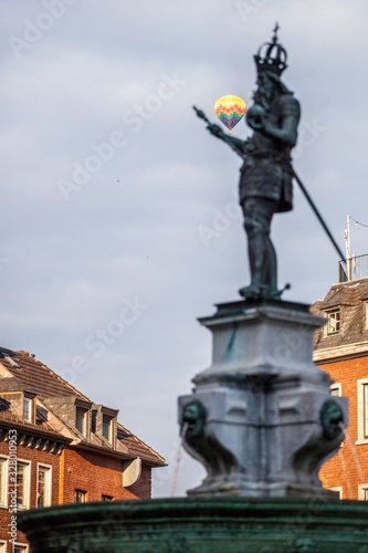 hot air balloon floating past statue of charlemagne