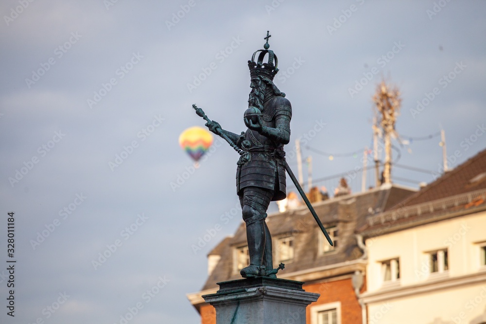 hot air balloon floating past statue of charlemagne