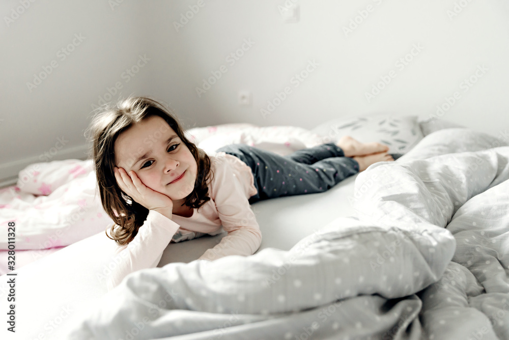 girl on the bed,top view of the girl who is in bed,girl lying and indulging in bed in the morning after waking up,happy child,the child indulges and rejoices,the baby is lying on the bed girl on the bed,top view of the girl who is in bed,girl lying and indulging in bed in the morning after waking up,happy child,the child indulges and rejoices,the baby is lying on the bed