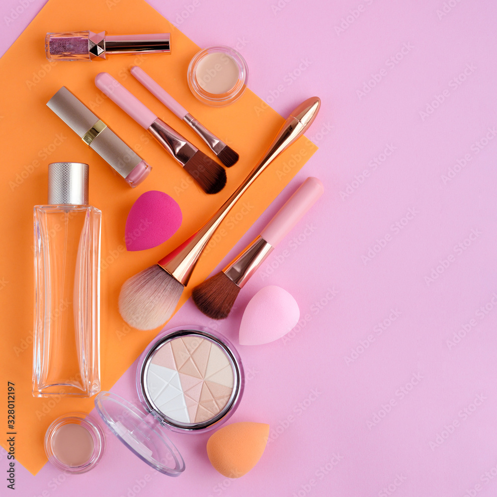 Naklejka premium Makeup brushes and decorative cosmetics on color background, with empty space for text. Top view