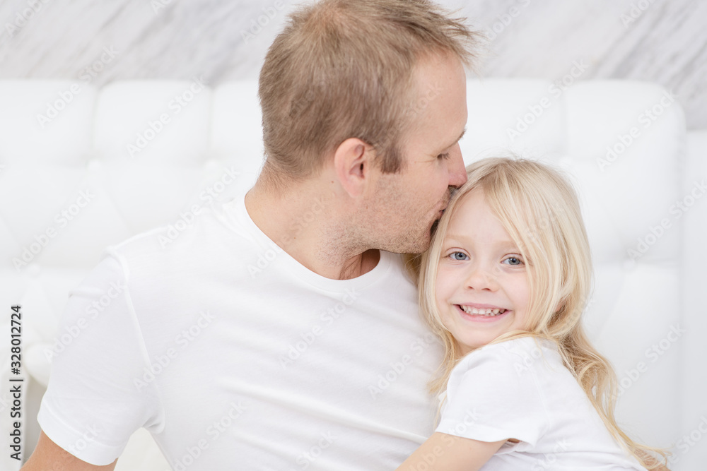 Close-up shot of young father kissing little smiling daughter. Sincere parents love Close-up shot of young father kissing little smiling daughter. Sincere parents love