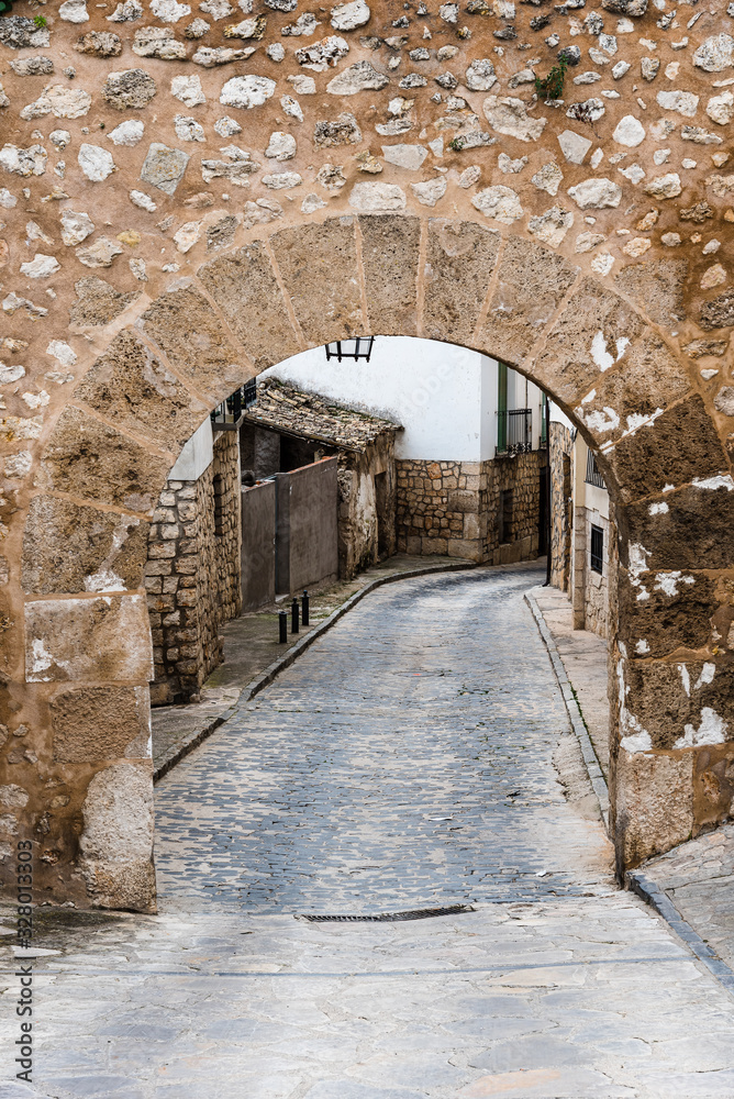 Street and stone arch in the medieval town of Pastrana in Spain