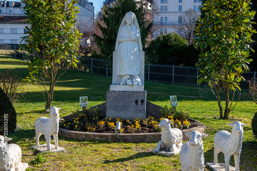 Canvas Print Statue of Bernadette of Lourdes with flowers