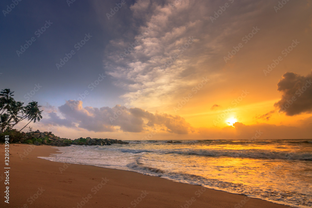 Bali, sanur, beautiful sunrise on the sea and beach with temples and plants, breakwaters, back light and beautiful sky with pale sea
