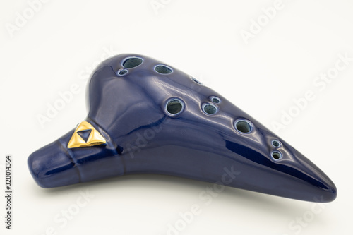 A dark blue ocarina in front of white background photo