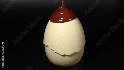 Melted hot chocolate. Chocolate is pouring on an egg. Chocolate desserts, sweets and confectionery.