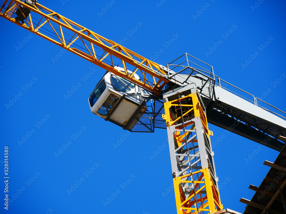 Crane. Self-erection crane. Tower crane against blue sky. Construction site.