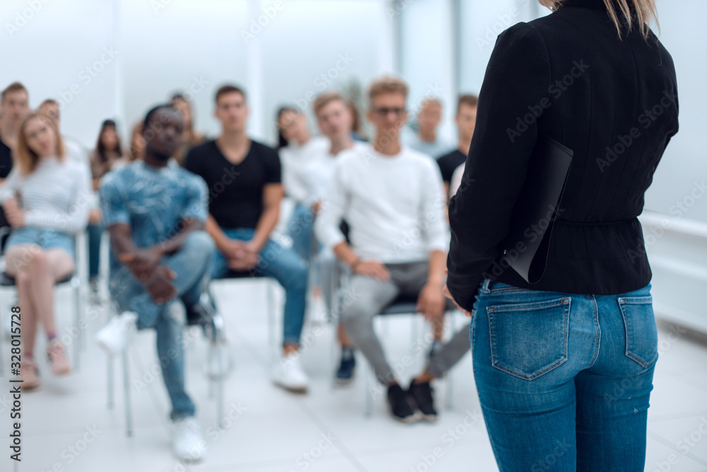 Fototapeta premium young woman standing in front of the audience in the conference room