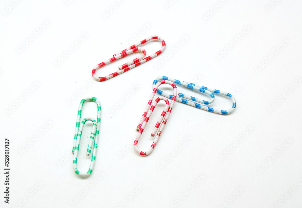 Multicolored office paper clips isolated on a white background. Office supplies. Stapling documents and paper with paper clips. Multicolored office paper clips isolated on a white background. Office supplies. Stapling documents and paper with paper clips.
