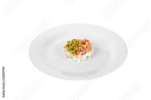 Russian salad with peas, red fish, chum salmon, eggs, cucumbers, carrots, potatoes on plate, side view white isolated background