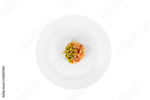 Russian salad with peas, red fish, chum salmon, eggs, cucumbers, carrots, potatoes on plate, view from above, white isolated background