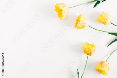 Fototapeta Naklejka Na Ścianę i Meble -  Beautiful composition of tulip, spring flowers. Yellow tulips flowers on white background. Valentine's Day, Easter, 8th march, Happy Women's Day, Mother's Day. Flat lay, top view, copy space