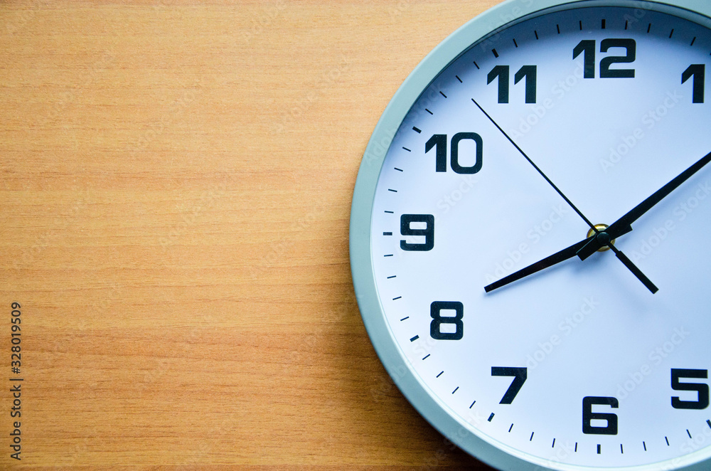 Analog clock on a wooden background. The watch is large in color and black and white. View from above. The clock is 20:05, 08:05. Copy Space Analog clock on a wooden background. The watch is large in color and black and white. View from above. The clock is 20:05, 08:05. Copy Space