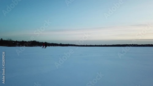 two person running in snow during blue hour, frozen lake in Minnesota, horizon photo