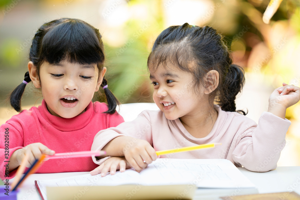 Asian student kid girl doing homework .Happy 2 sisters enjoy learning with happiness at home. Education concept Asian student kid girl doing homework .Happy 2 sisters enjoy learning with happiness at home. Education concept