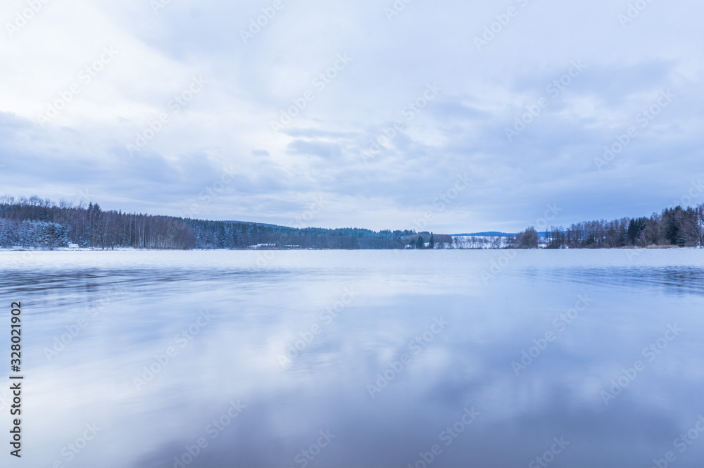 Sky and clounds reflecting in the lake in winter Sky and clounds reflecting in the lake in winter