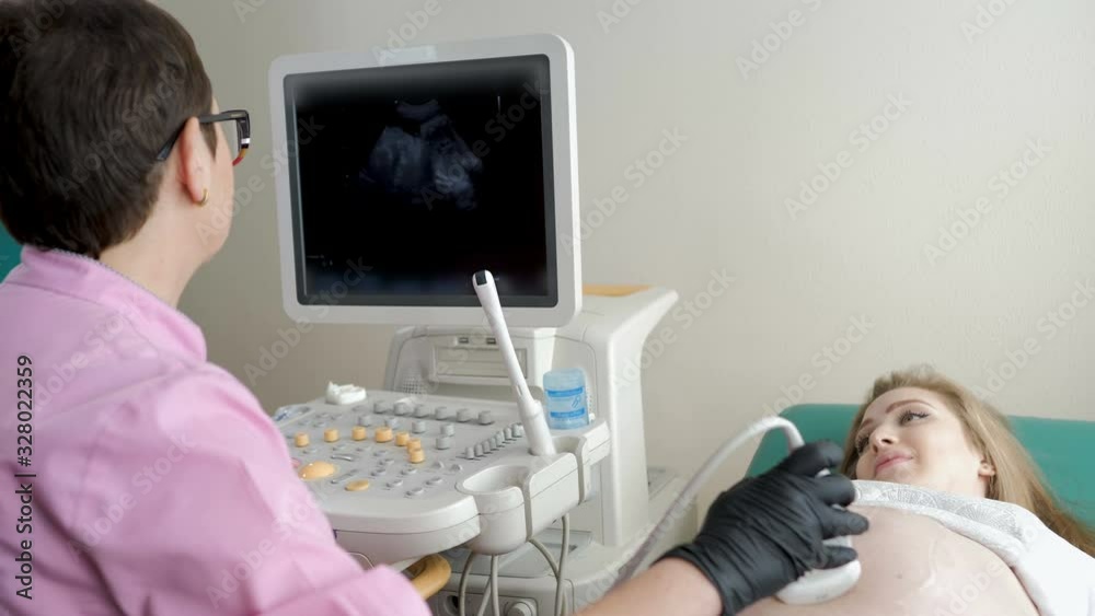 Process of ultrasonography, doctor checking baby in happy pregnant woman belly, modern medical technology Process of ultrasonography, doctor checking baby in happy pregnant woman belly, modern medical technology