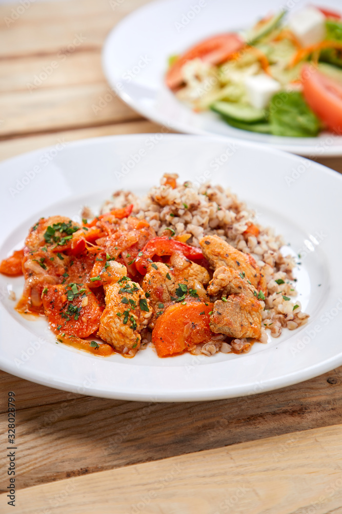 meat with buckwheat and salad on the wooden background