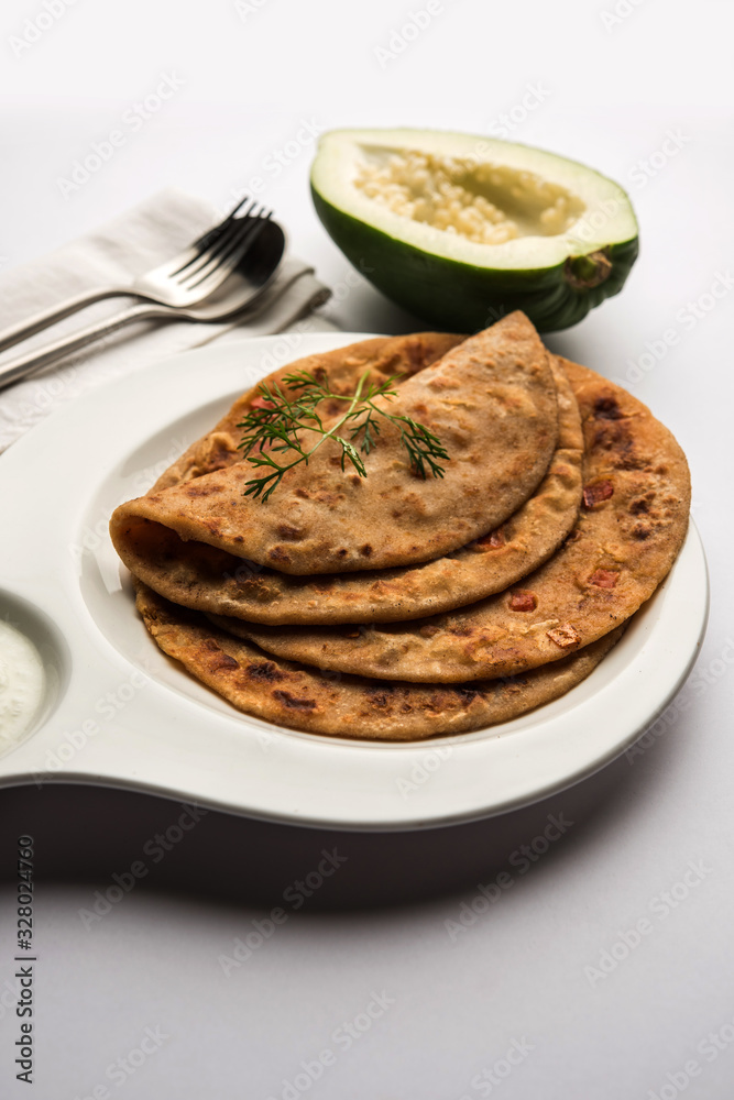 Raw Papaya Paratha or Papita ke Parathe made using Made using papaya, wheat flour, cumin seeds, ginger. Popular Indian food recipe served hot with curd. selective focus Raw Papaya Paratha or Papita ke Parathe made using Made using papaya, wheat flour, cumin seeds, ginger. Popular Indian food recipe served hot with curd. selective focus
