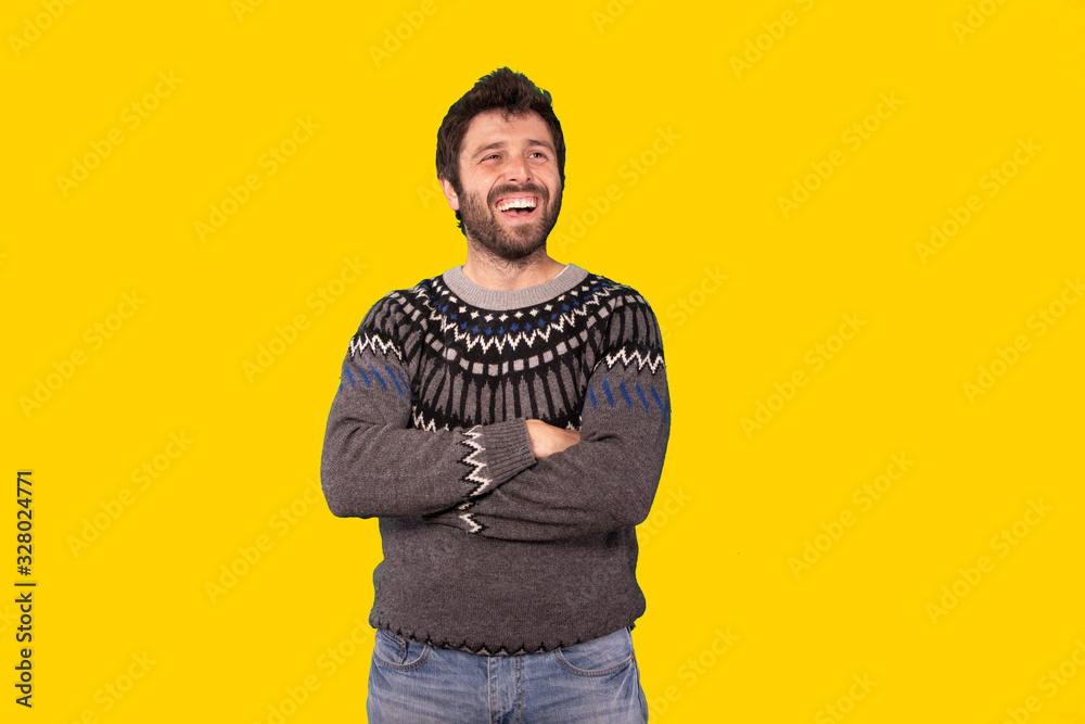 young handsome man smiling with a happy, confident expression, wondering and looking to the side over yellow background