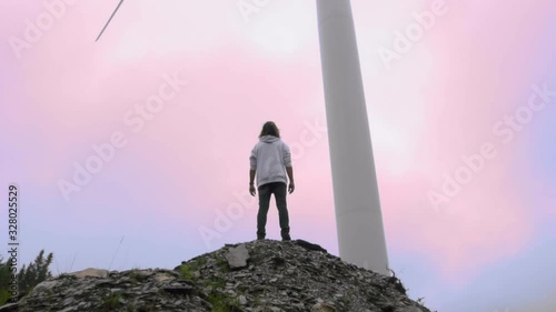 Man standing on a hill with a crismon sky photo