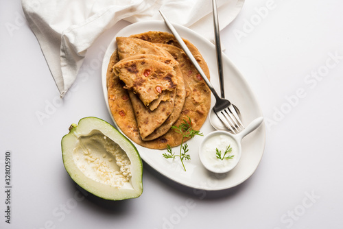 Raw Papaya Paratha or Papita ke Parathe made using Made using papaya, wheat flour, cumin seeds, ginger. Popular Indian food recipe served hot with curd. selective focus photo