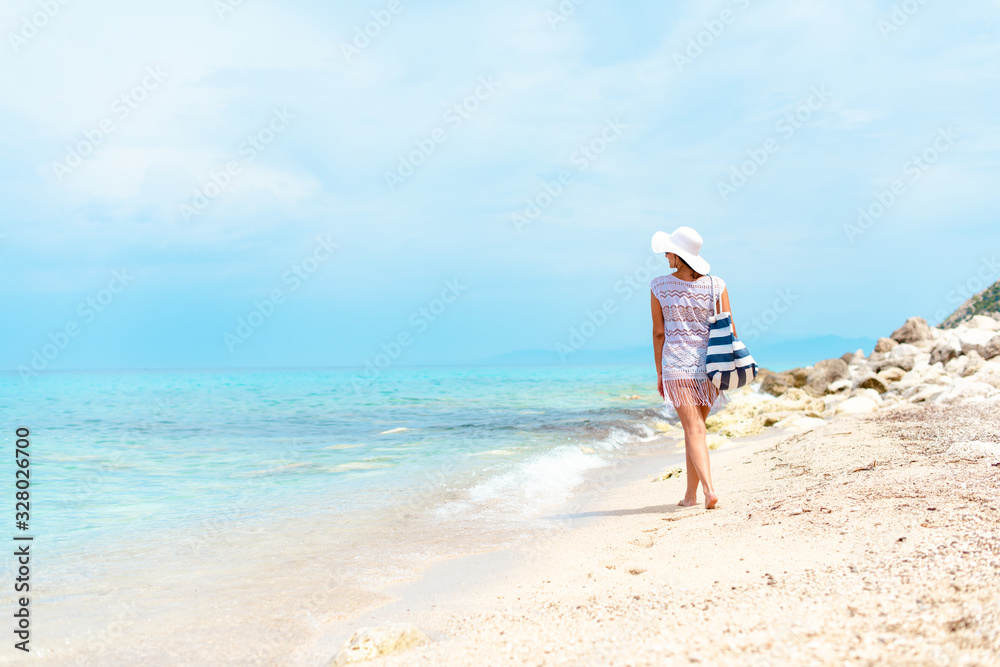 A women in white with sunglasses enjoying on the beach