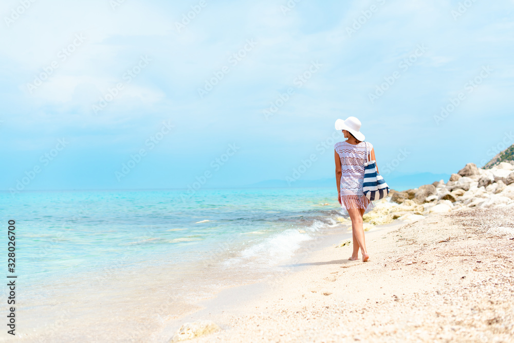 A women in white with sunglasses enjoying on the beach A women in white with sunglasses enjoying on the beach