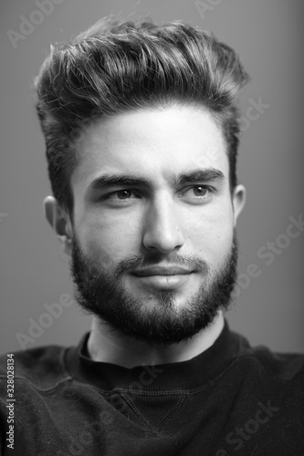 Close-up black and white portrait of a young handsome Caucasian male in studio. A man shows different human emotions.