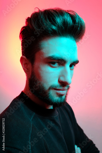 Beautiful caucasian young man portrait isolated on multicolored neon light backgroud. Young, smiling, surprised, screaming. Human emotions, facial expression concept. Trendy colors.Advertising concept