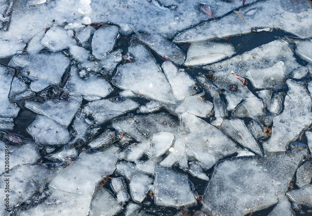 Drifting spring ice pieces on the river. Early spring background. Texture of floating ice.